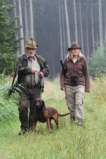 Huntsman and huntress, accompanied by hunting dog Bavarian Mountain Hound, Allgaeu, Bavaria, Germany, Europe