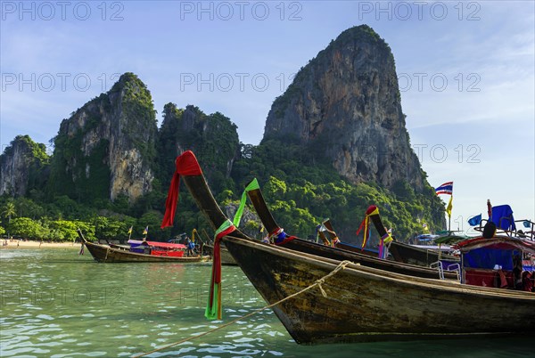 Longtail boat for transporting tourists, water taxi, taxi boat, ferry, ferry boat, fishing boat, wooden boat, boat, decorated, tradition, traditional, bay, sea, ocean, Andaman Sea, tropics, tropical, chalk cliffs, landscape, island, water, travel, tourism, paradisiacal, beach holiday, sun, sunny, holiday, dream trip, holiday paradise, paradise, coastal landscape, nature, idyllic, turquoise, Siam, exotic, travel photo, Krabi, Thailand, Asia