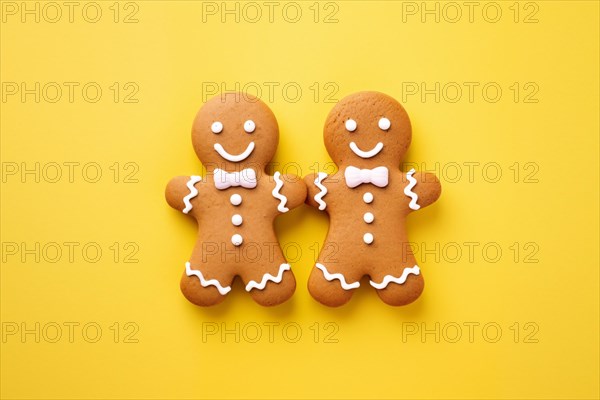 Pair of cute gingerbread cookie men on yellow background. KI generiert, generiert AI generated