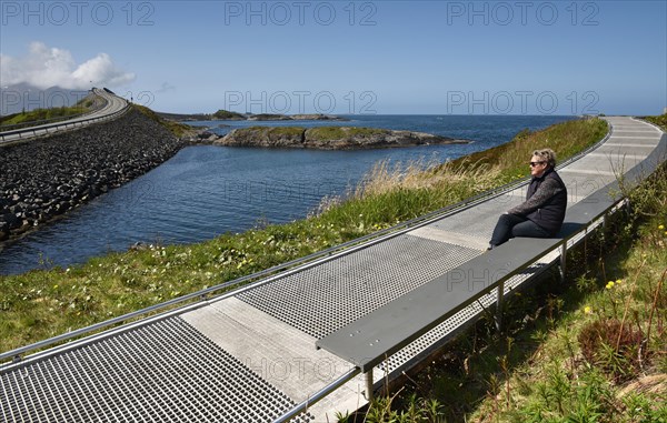 Woman sitting in an archipelago on the Atlantic Road in Norway