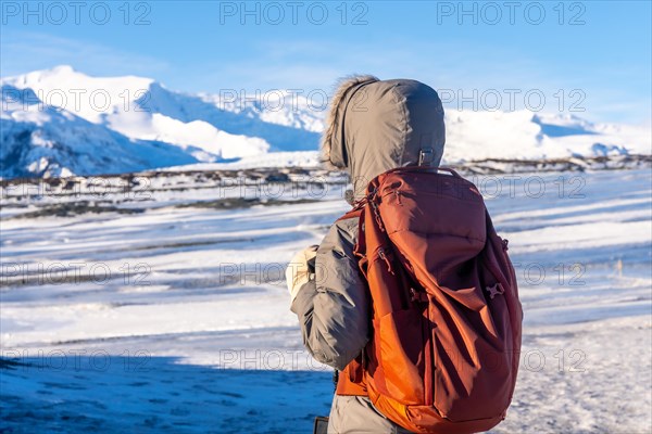 A woman on her back in winter Iceland on the Breidarlon glacier next to Jokulsarlon