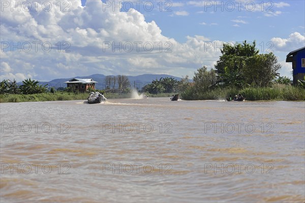 Two speedboats travelling side by side on a wide river, Inle Lake, Myanmar, Asia