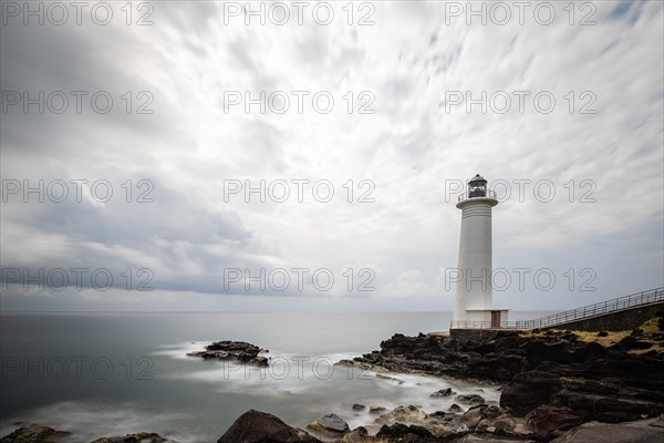 White lighthouse on a steep coast. Dramatic clouds with a view of the sea, pure Caribbean at Le Phare du Vieux-Fort, on Guadeloupe, French Antilles, France, Europe