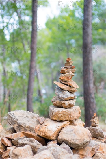 Carefully stacked, slightly red stones form a stone figure, cairn, waymark, marker, sparse pine forest, hiking trail from Sant Elm to the old watchtower Torre Cala Basset, Balance, Serra de Tramuntana, Mediterranean island Majorca, Spain, Europe
