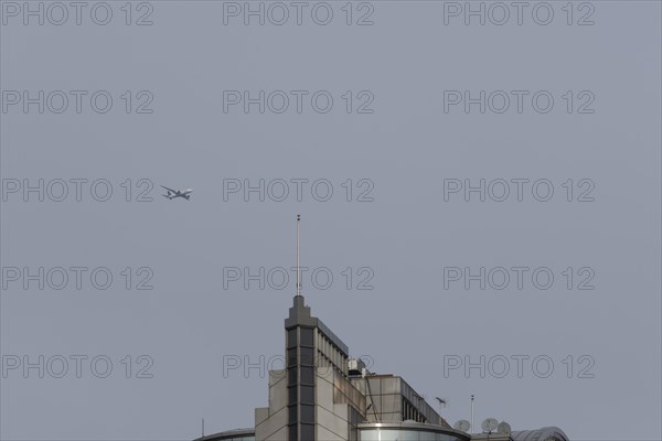 Airbus aircraft in flight over a city skyscraper building, London, England, United Kingdom, Europe