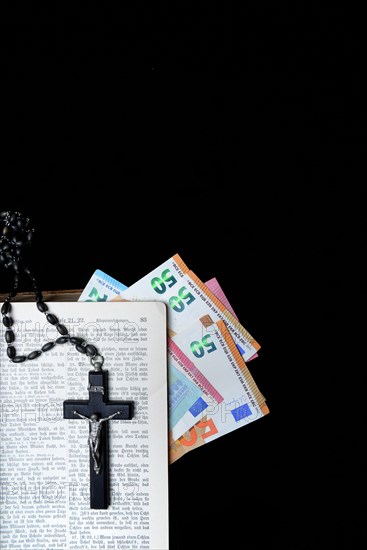 Bible, crucifix and banknotes, church and money, church tax