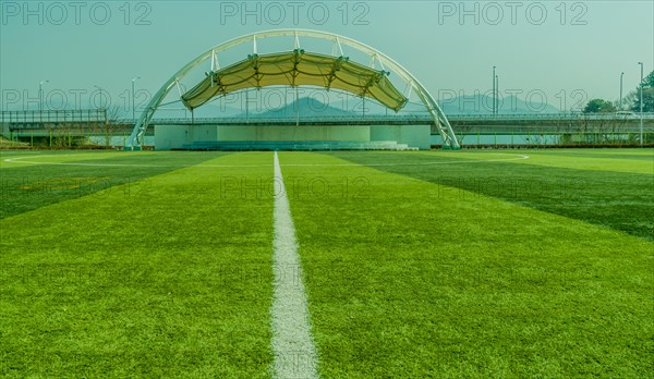 Soccer field with a white line and canopy structure under a clear sky, in South Korea