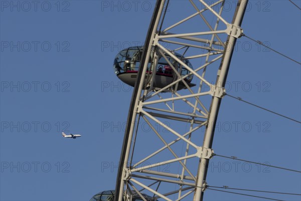 Airbus A319-100 aircraft of British airways in flight behind the pods of the London Eye or Millennium Wheel, London, England, United Kingdom, Europe