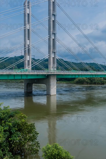 Tall suspension bridge over a river seen on a day with a cloudy sky, in South Korea