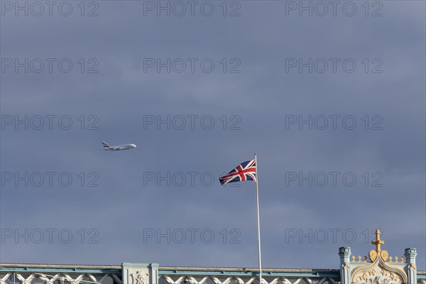 Airbus A380 aircraft of Emirates airlines in flight with a Union Jack flag on Tower Bridge in the foreground, London, England, United Kingdom, Europe
