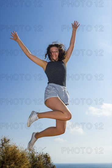 Happy young woman on summer holiday, jump, jumping, jumping, young, glad, happy, luck, joy, emotion, hair, fun, joie de vivre, sun, summer, summer holiday, holiday happiness, tourism, travel, symbolic, symbol, beach holiday, freedom, feeling of freedom, elan, fit, healthy, health, vital, fitness, natural, unadorned, authentic, self-confident, self-assurance, Algarve, Portugal, Europe