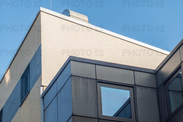 Modern corner of a building with windows under a clear blue sky