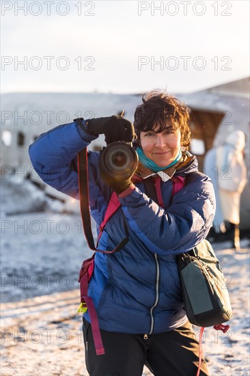Portrait of adventurous photographer woman smiling in winter in Iceland on the plane in Solheimasandur
