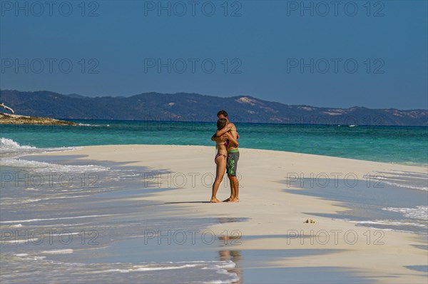 Couple in live standing on white sand beach, island of Nosy Iranja near Nosy Be, Madagascar, Africa