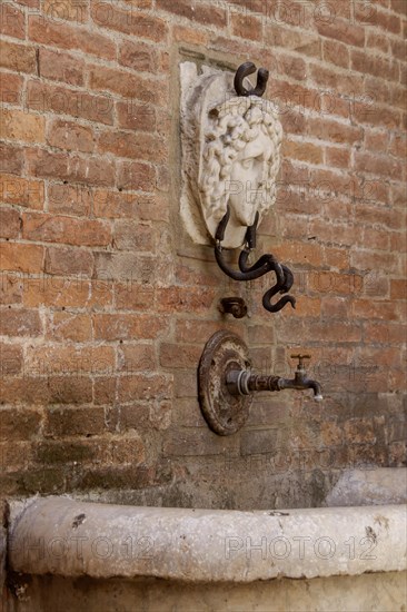 Detail of the Mencia Fountain in the historic centre of Asciano, Crete Senesi, Tuscany, Italy, Europe