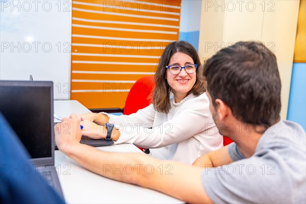 Mental disabled woman and teacher talking during a computing class