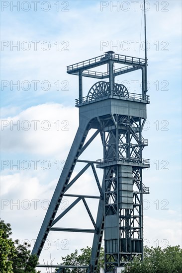 Historic winding tower of a colliery with complex metal structure in front of a partly cloudy sky, Oberhausen, North Rhine-Westphalia, Germany, Europe