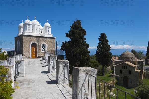Church with classical architecture, surrounded by trees and blue sky, on the right Temple of Apollo of ancient Assina, Byzantine fortress with nunnery, Holy Monastery of Timi Prodromos, Koroni, Pylos-Nestor, Messinia, Peloponnese, Greece, Europe