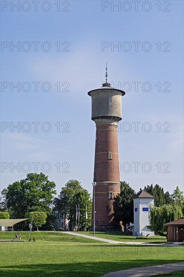 Brick water tower stands on a green lawn under a clear blue sky, Ladenburg, Baden-Wuerttemberg, Germany, Europe
