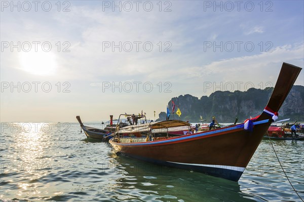 Longtail boat for transporting tourists, water taxi, taxi boat, ferry, ferry boat, fishing boat, wooden boat, boat, decorated, tradition, traditional, bay, sea, ocean, Andaman Sea, tropics, tropical, chalk cliffs, landscape, island, water, travel, tourism, paradisiacal, beach holiday, sun, sunny, holiday, dream trip, holiday paradise, paradise, coastal landscape, nature, idyllic, turquoise, Siam, exotic, travel photo, Krabi, Thailand, Asia