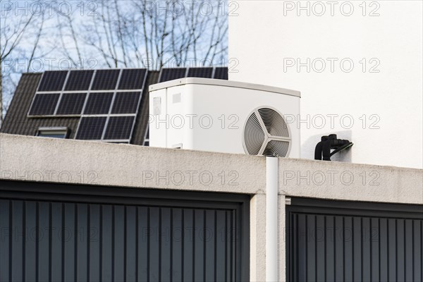 Heat pump on a garage roof of a new development, in the background solar panels are mounted on house roofs, Monheim am Rhein, North Rhine-Westphalia, Germany, Europe