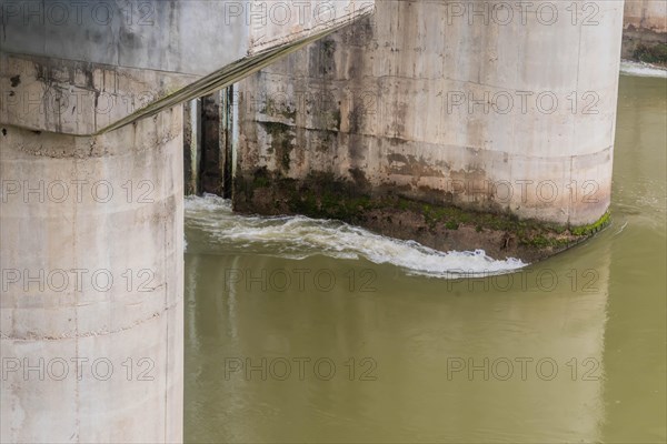 Algae and moss on a concrete bridge structure show signs of water flow and erosion, in South Korea