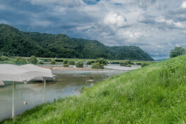 Landscape of flooded baseball diamond and island of trash floating on surface of water after torrential monsoon rains in Daejeon South Korea