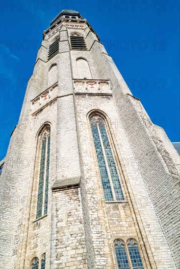 View of a high church tower with decorative windows against the sky