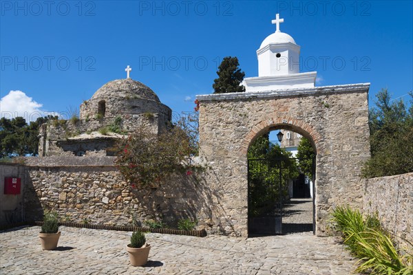 Traditional chapel behind an old wall under a clear blue sky on a sunny day, Stone church with arched gate, Church of St Sophia, Byzantine fortress, Nunnery, Monastery, Koroni, Pylos-Nestor, Messinia, Peloponnese, Greece, Europe