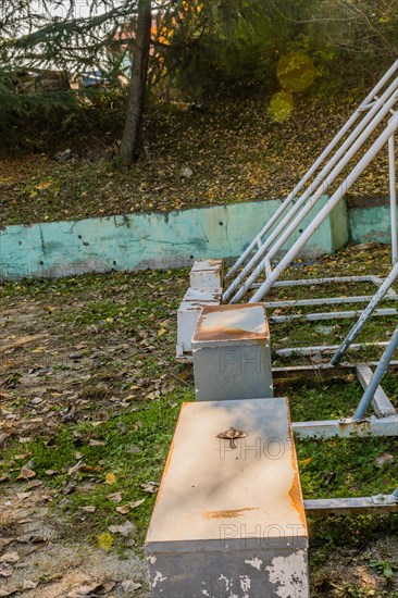 Neglected and rusty sports seating with scattered fallen leaves, in South Korea