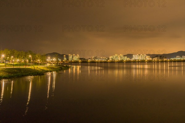 Night scene of lake side park in South Korea with city lights reflecting in the water in Sejeong, South Korea, Asia