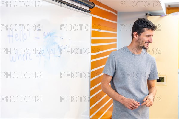 Teacher using white board during a IT computer class with disabled people