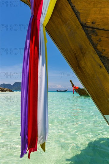 Longtail boat, fishing boat, wooden boat, decorated, tradition, traditional, faith, cloth, colourful, bay, sea, ocean, Andaman Sea, tropical, tropical, island, water, beach, beach holiday, Caribbean, environment, clear, clear, clean, peaceful, picturesque, sea level, climate, travel, tourism, paradisiacal, beach holiday, sun, sunny, holiday, dream trip, holiday paradise, paradise, coastal landscape, nature, idyllic, turquoise, Siam, exotic, travel photo, sandy beach, Phi Phi Island, Thailand, Asia