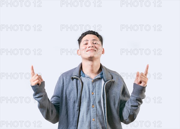 Happy handsome man pointing an advertising up isolated. Young man pointing blank space up and smiling at camera