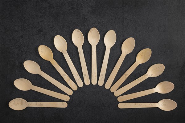 Fan-shaped arrangement of wooden spoons on a dark background