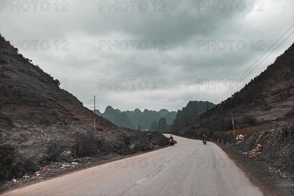 Dark and moody cinematic scenery of an empty road to the mountains in Dong Van, Vietnam, Asia