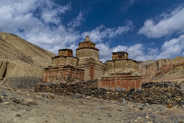 Colourfully painted Buddhist stupa, in a eroded mountain landscape, Kingdom of Mustang, Nepal, Asia