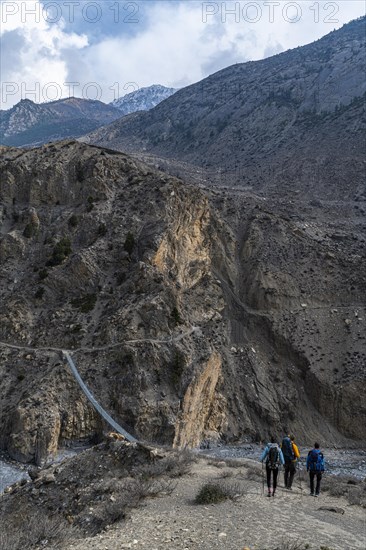 Tourists hiking a huge hanging bridge, Kingdom of Mustang, Nepal, Asia