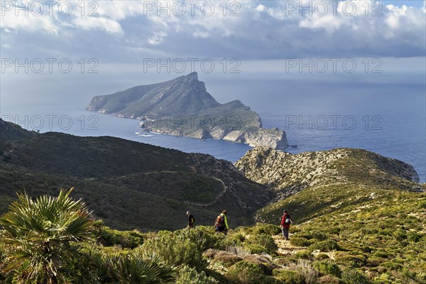 Two hikers on a mountain trail with panoramic views of the sea and surrounding greenery, Hiking tour in Tramuntana Mountains, Mallorca