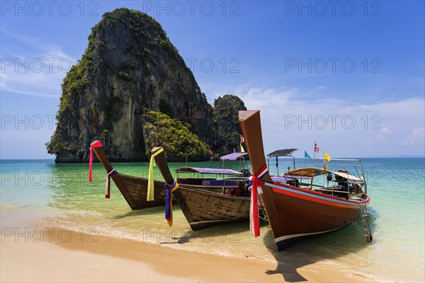 Longtail boat, fishing boat, wooden boat, boat, decorated, tradition, traditional, faith, cloth, colourful, bay, sea, ocean, tropical, tropical, island, water, beach, beach holiday, Caribbean, environment, peaceful, picturesque, sea level, climate, travel, tourism, paradisiacal, beach holiday, sun, sunny, holiday, dream trip, holiday paradise, paradise, coastal landscape, nature, idyllic, turquoise, Siam, exotic, travel photo, sandy beach, seascape, limestone, rocks, limestone cliffs, Krabi, Thailand, Asia