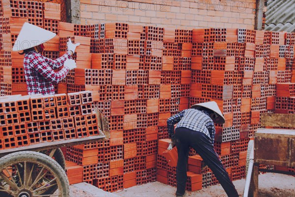 Workers in the traditional brick-making village along the banks of the Co Chien River in Vinh Long Province, Vietnam, Asia