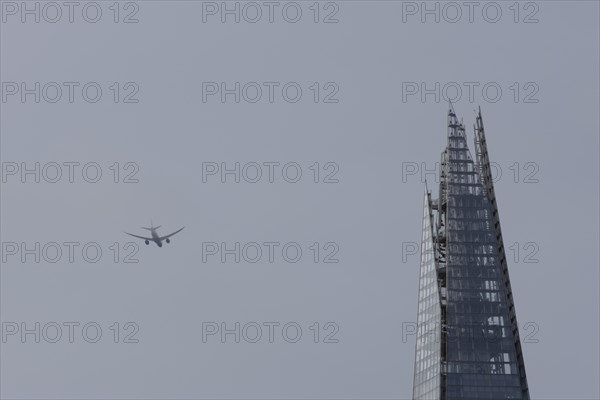 Airbus A319-100 aircraft of British airways in flight over The Shard city skyscraper building, London, England, United Kingdom, Europe