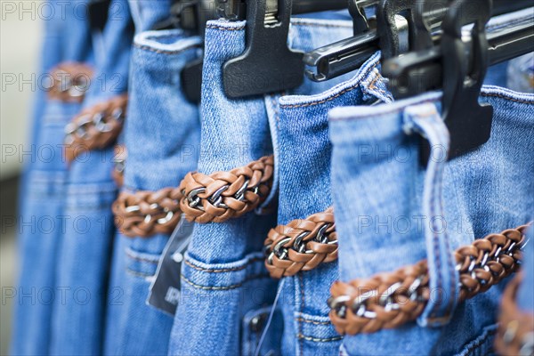 Blue Jeans with Belt Hanging on Clothes Hanger in a Shop in Switzerland