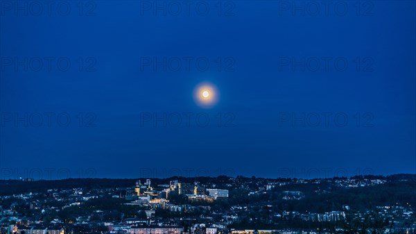 Full moon over a city at night with a hilly landscape and subdued lighting, Bergische Universitaet, Elberfeld, Wuppertal, Bergisches Land, North Rhine-Westphalia