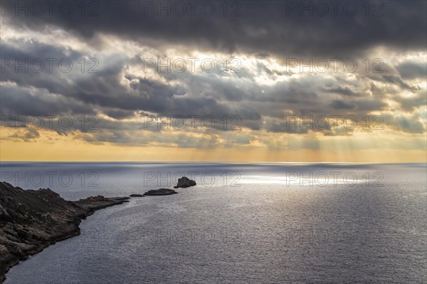 Dramatic sunset over the sea with a serene coastline under cloud-filled sky, Coastal Hiking tour in the south of Mallorca