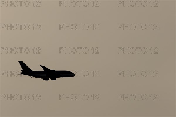 Airbus A380 aircraft in flight silhouette at sunset, England, United Kingdom, Europe