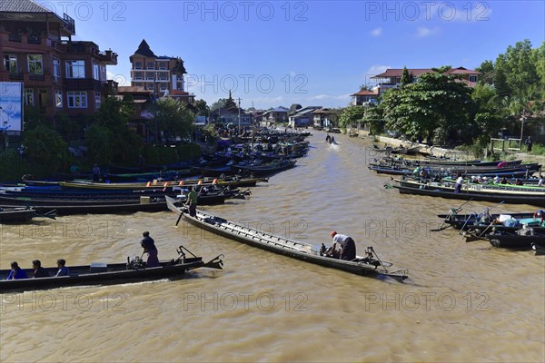 People on boats on a river with city silhouette in the background, Pindaya, Inle Lake, Myanmar, Asia