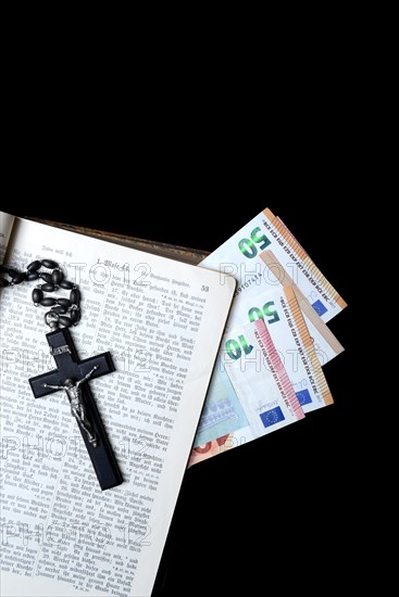 Bible, crucifix and banknotes, church and money, church tax