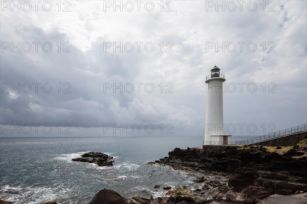 White lighthouse on a steep coast. Dramatic clouds with a view of the sea, pure Caribbean at Le Phare du Vieux-Fort, on Guadeloupe, French Antilles, France, Europe