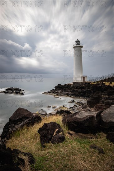 White lighthouse on a steep coast. Dramatic clouds with a view of the sea, pure Caribbean at Le Phare du Vieux-Fort, on Guadeloupe, French Antilles, France, Europe